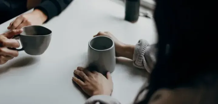 Two people talking over coffee